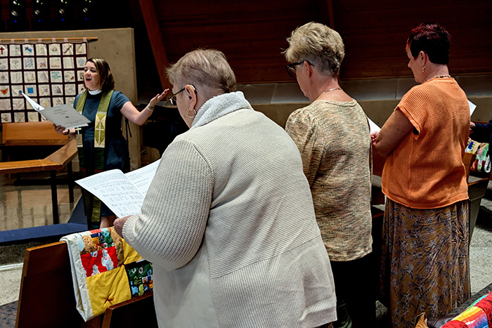 Congregants singing during a Sunday service with Pastor Sara