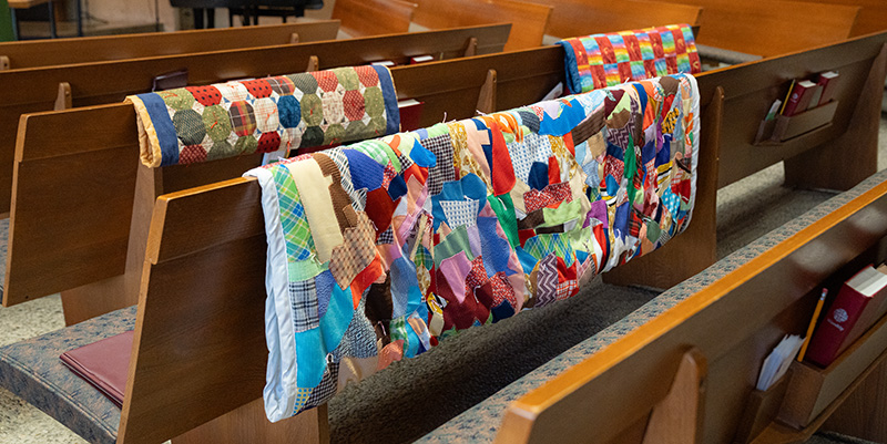 Quilts laid on the backs of the pews inside the church