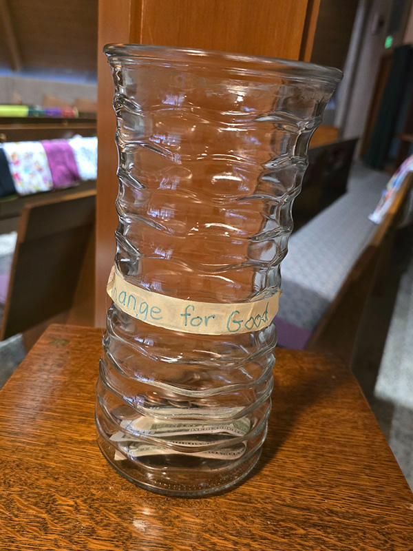 A mostly-empty vase with tape on it titled, "Change for Good"